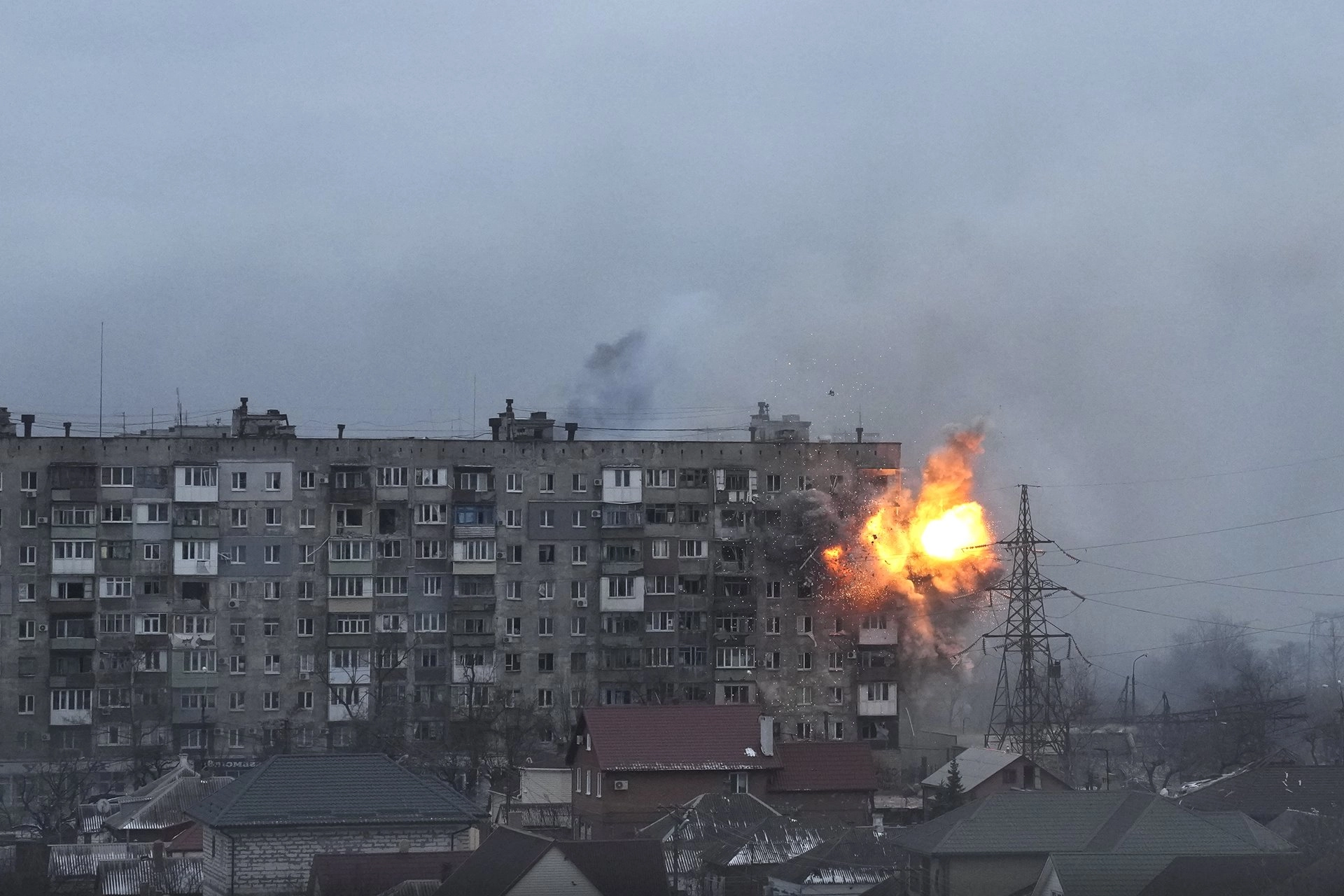 An explosion erupts from an apartment building on Mytropolytska Street, Mariupol, Ukraine, after fire from a Russian army tank.