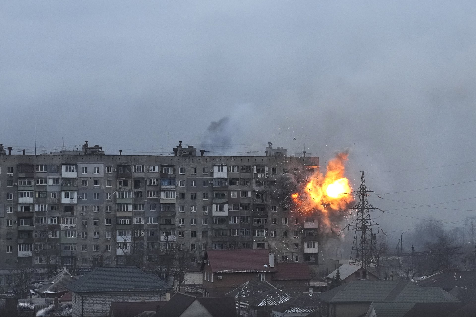 An explosion erupts from an apartment building on Mytropolytska Street, Mariupol, Ukraine, after fire from a Russian army tank.